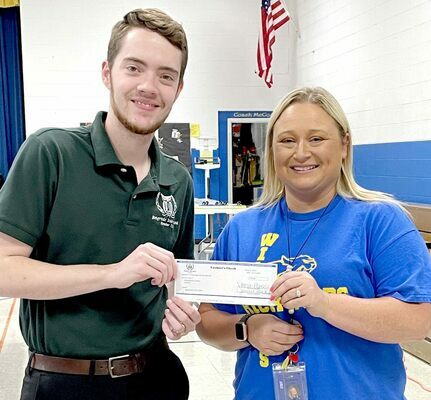 Hunter Ives donating to Principal Ginny Wills. (Submitted Photo)